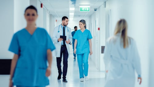Doctors and nurses walking down hospital hallway leveraging continuous intelligence for real-time patient outcomes
